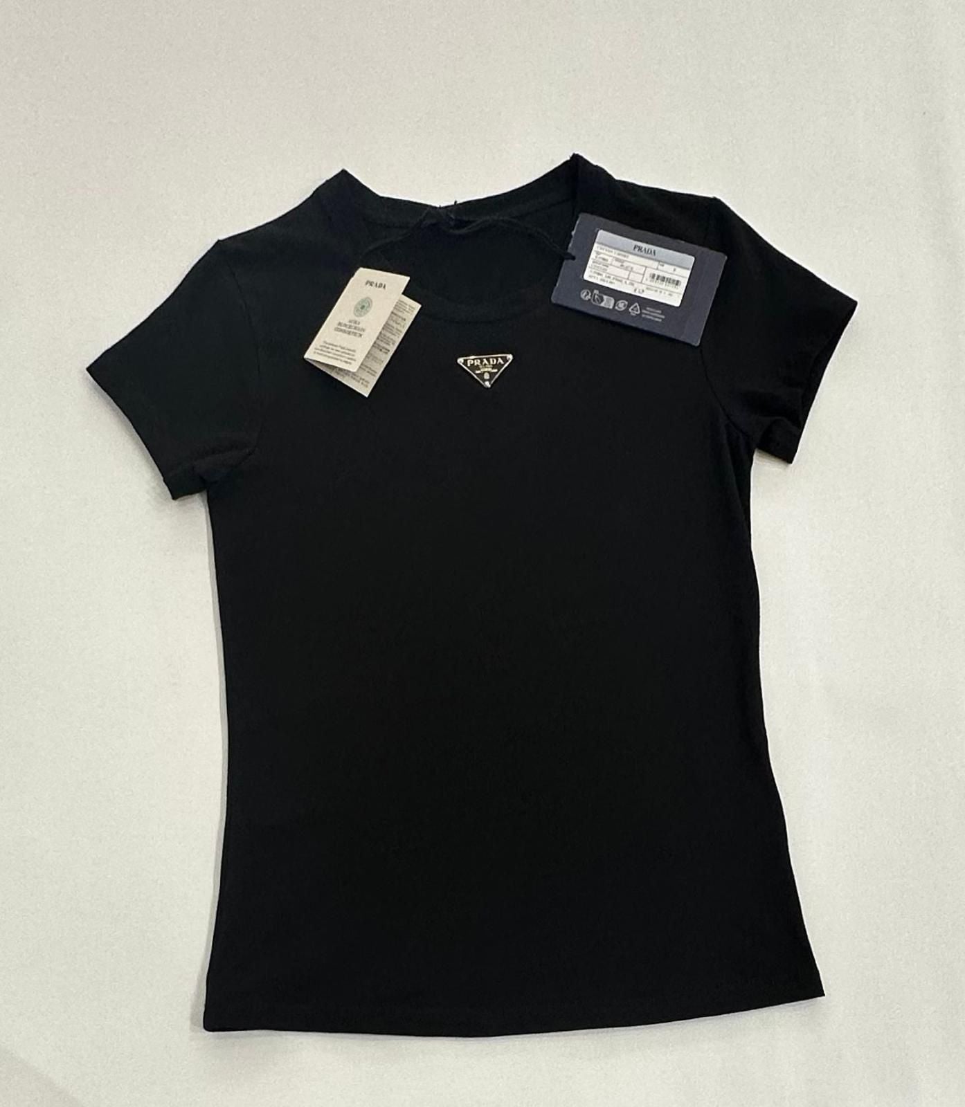Black t-shirt with a brand logo and tags on a light gray background
