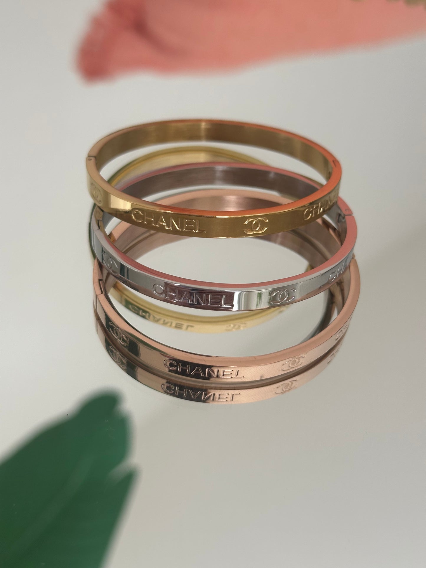 Four Swarovski branded bangles stacked on a light gray background