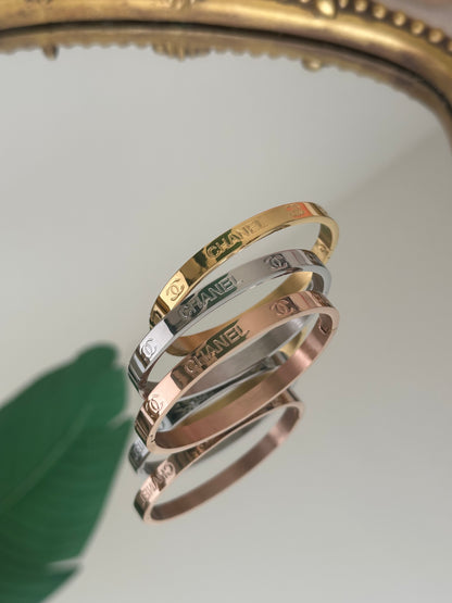 Set of gold, silver, and rose gold bracelets on a white surface.